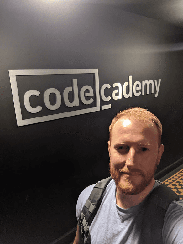Dan Layfield in front of the Codecademy office sign on his last day, 2021